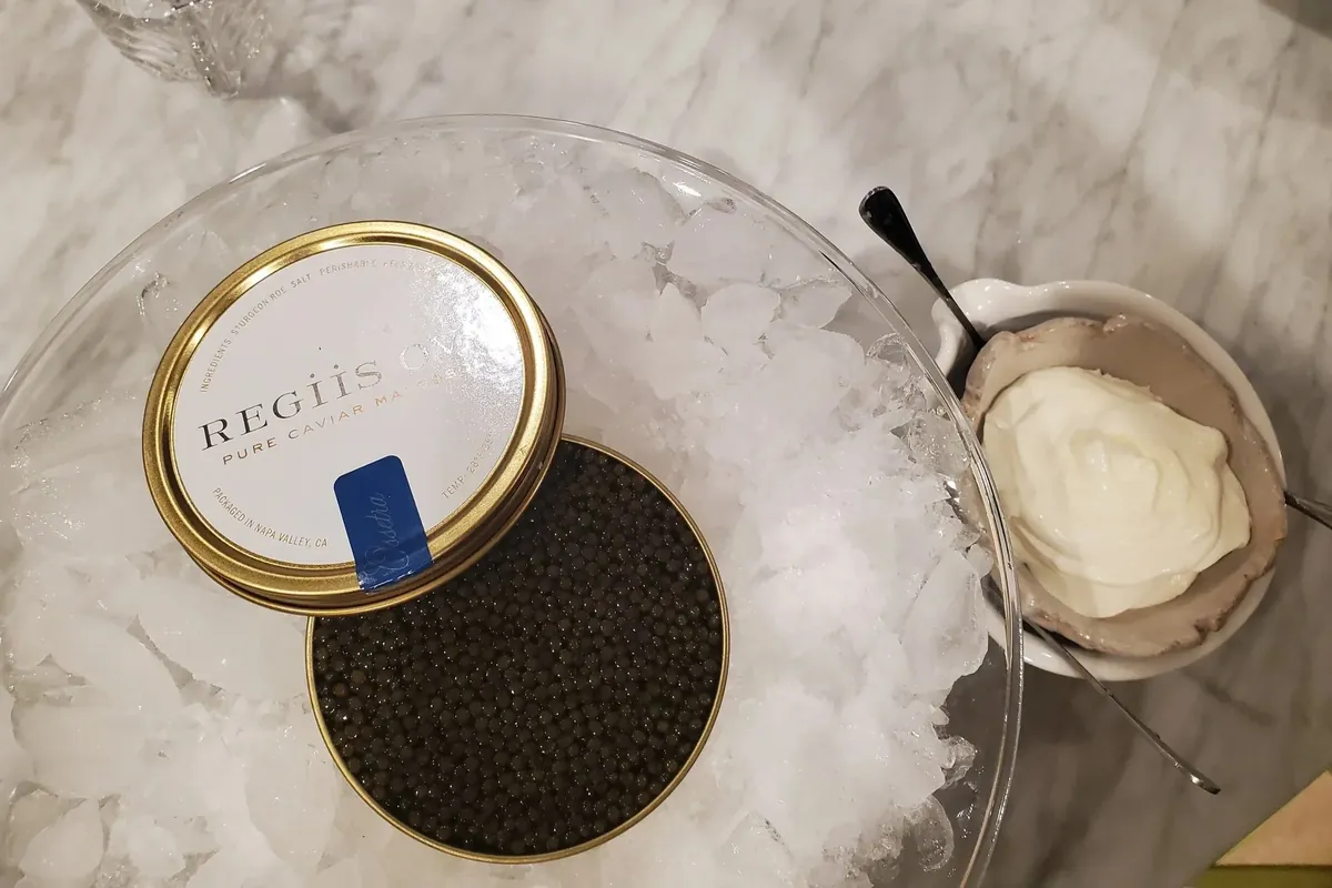 Caviar tin with creme fraiche on marble